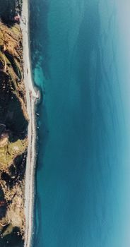 Stunning aerial view of a coastal road alongside deep blue ocean waters, capturing the scenic beauty of nature.