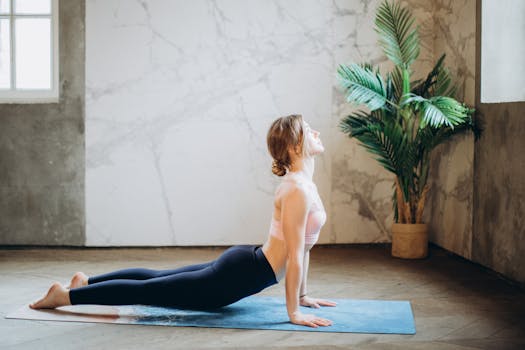 Woman in Pink Sports Bra and Black Leggings Doing Yoga on Yoga Mat