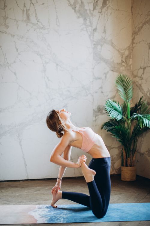 Free A woman in activewear performing a yoga pose indoors, showcasing flexibility and grace. Stock Photo