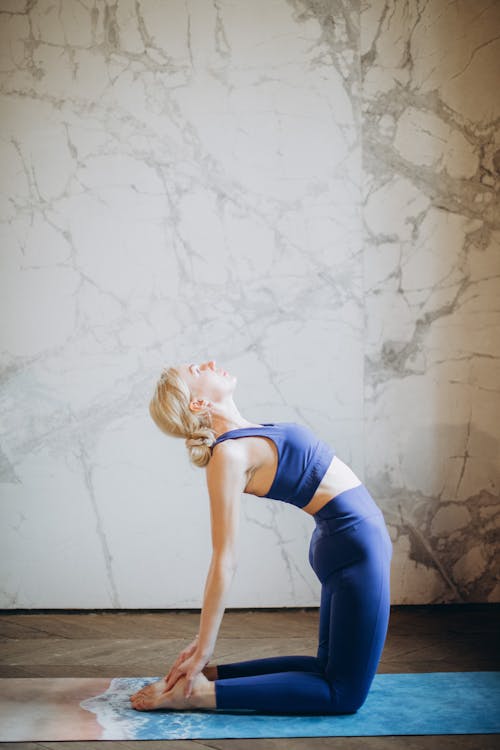 Woman in Blue Tank Top and Blue Leggings Doing Yoga