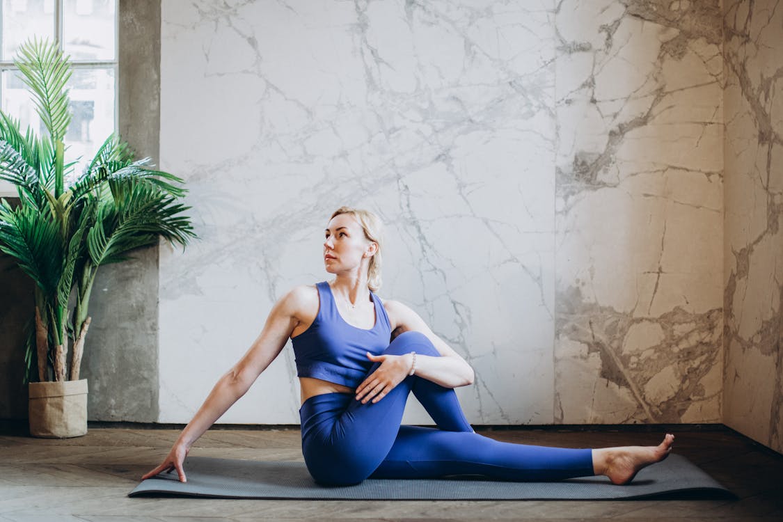 Free Woman in Blue Tank Top and Blue Leggings Doing Yoga Stock Photo