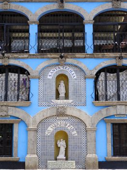 Colorful facade featuring Santa Cecilia statue in Ciudad de México. Unique architectural design.