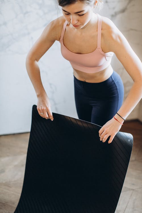 Gratis Mujer Configurando Su Esterilla De Yoga Foto de stock