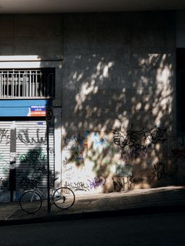 Street scene with graffiti and shadows on a wall in Belo Horizonte, Brazil. Includes a parked bicycle.