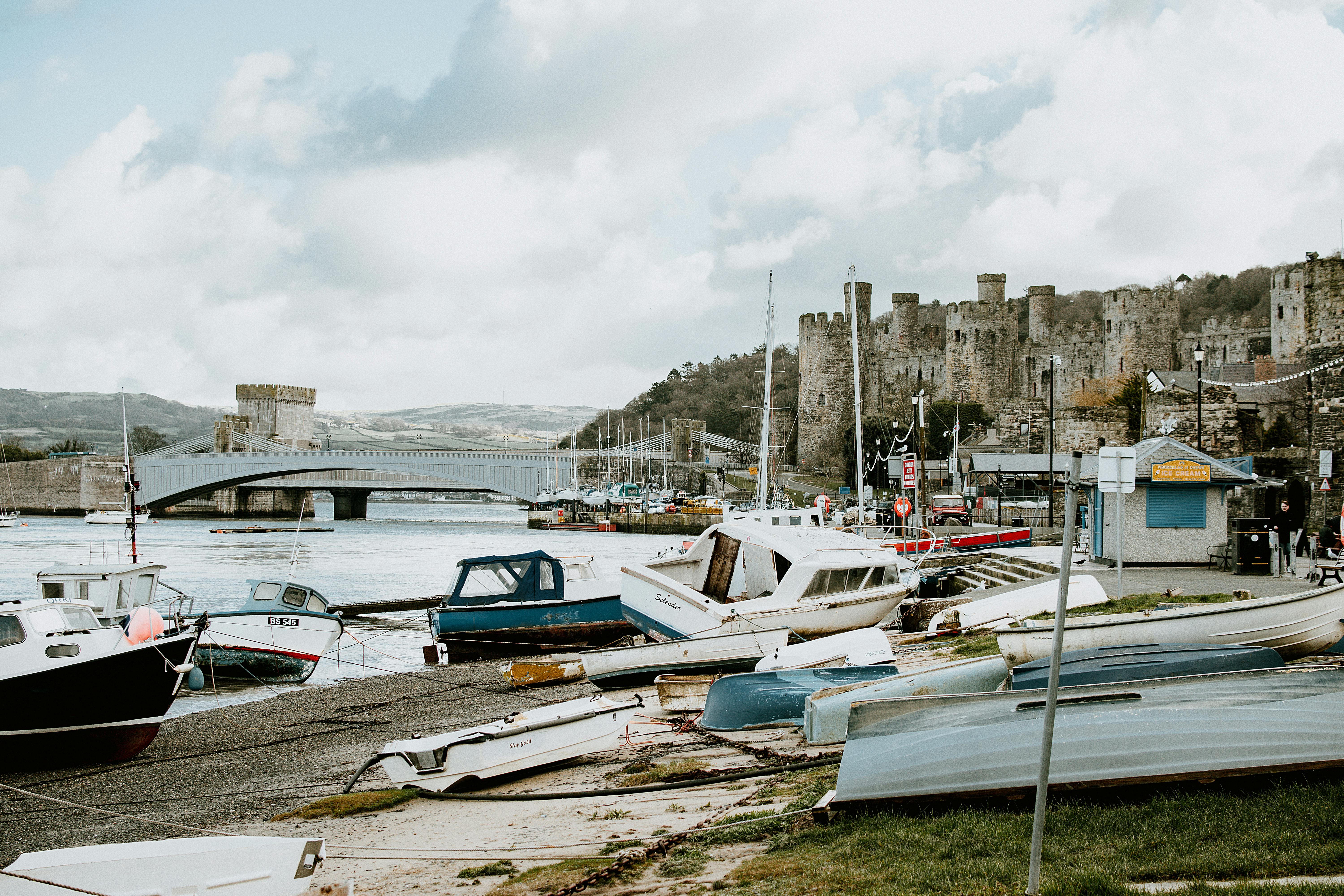 A beautiful view of Conwy Castle with boats in the harbor, showcasing a historic Welsh landmark.