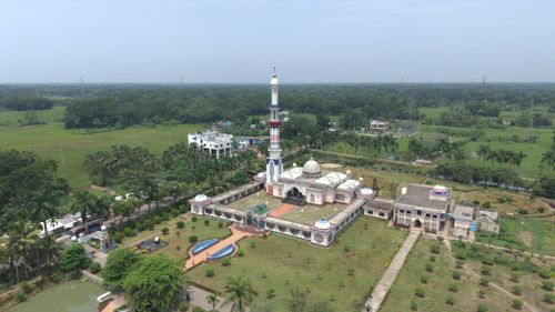 Free A stunning aerial view of a mosque surrounded by lush greenery on a clear day. Stock Photo