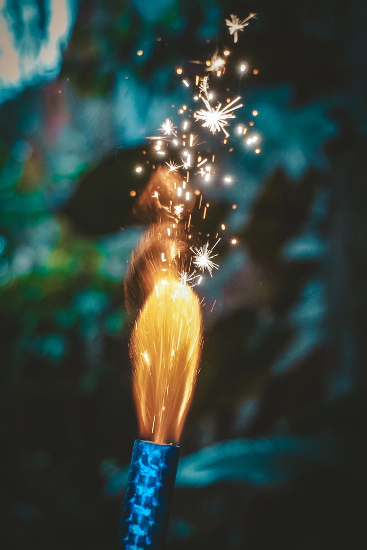 Bright Firework Candle Burning On Blurred Background In Evening