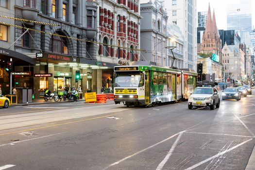 Evening traffic with a central tram at Flinders Street, Melbourne, Australia.