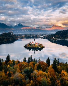 Stunning aerial capture of Lake Bled with vibrant fall colors and an iconic island church.