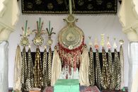 Intricate religious artifacts displayed with rich tapestry and ornate metals indoors.