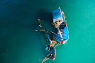 From above picturesque view of boats floating in ocean bright green water in daylight