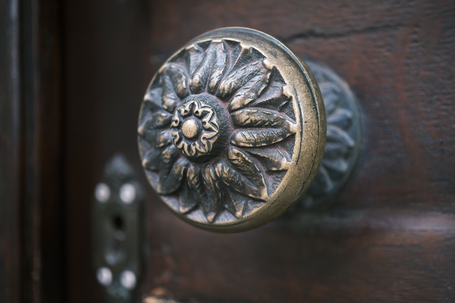 A vintage brass door knob on a solid timber door