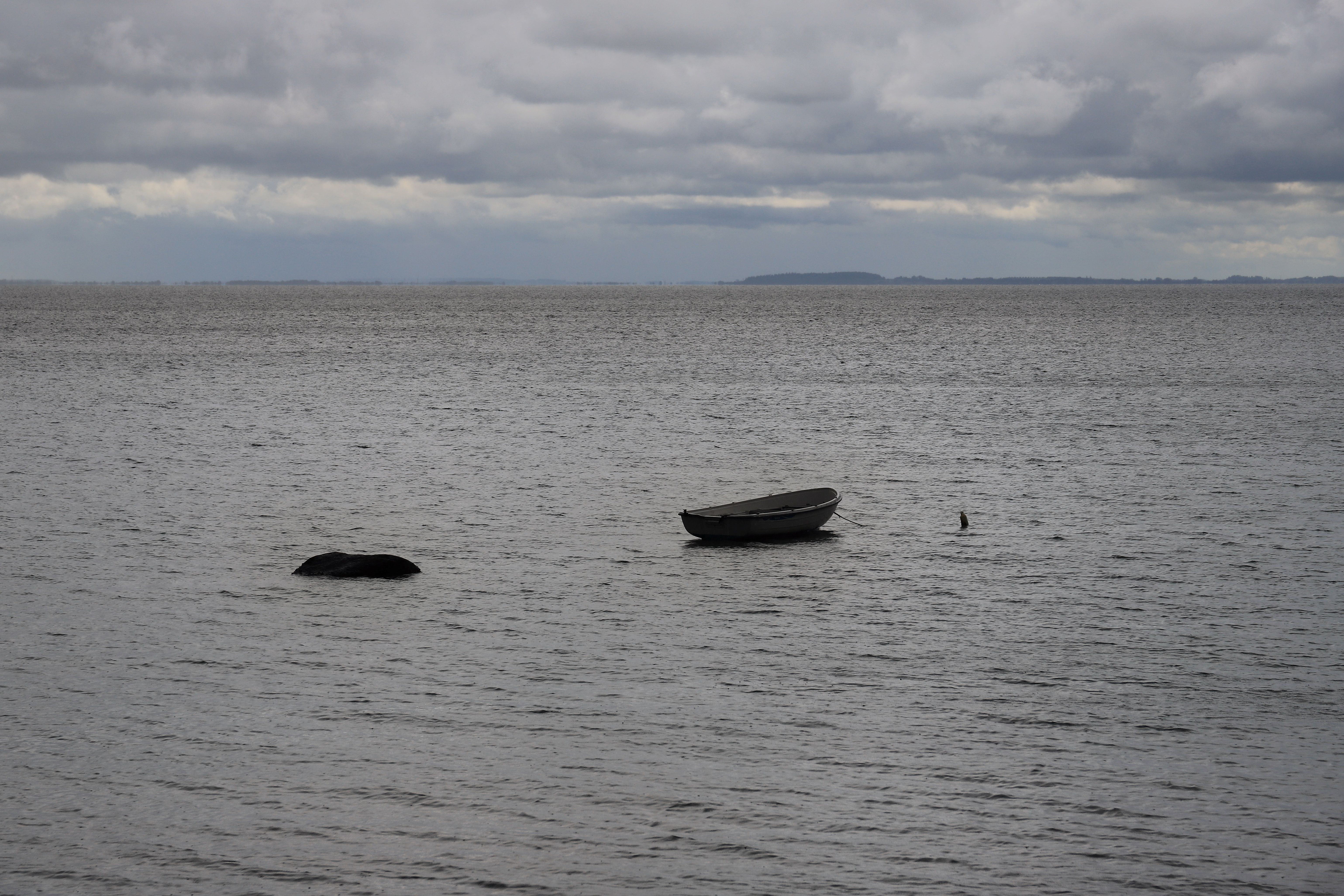 An empty fishing boat alone on a grey sea