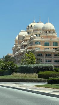 Elegant luxury building with unique domes set against a clear blue sky in Dubai.