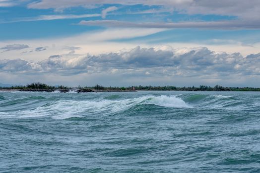 Dramatic ocean waves breaking under a cloudy sky, capturing nature's raw beauty.