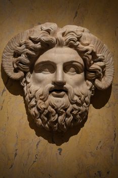 Intricate Roman marble sculpture depicting a horned deity, highlighting ancient artistry.