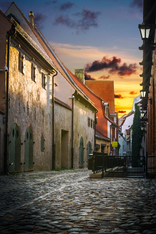 Cobblestone pathway between building facades at colorful sunset in evening