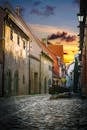 Cobblestone pathway between building facades at colorful sunset in evening