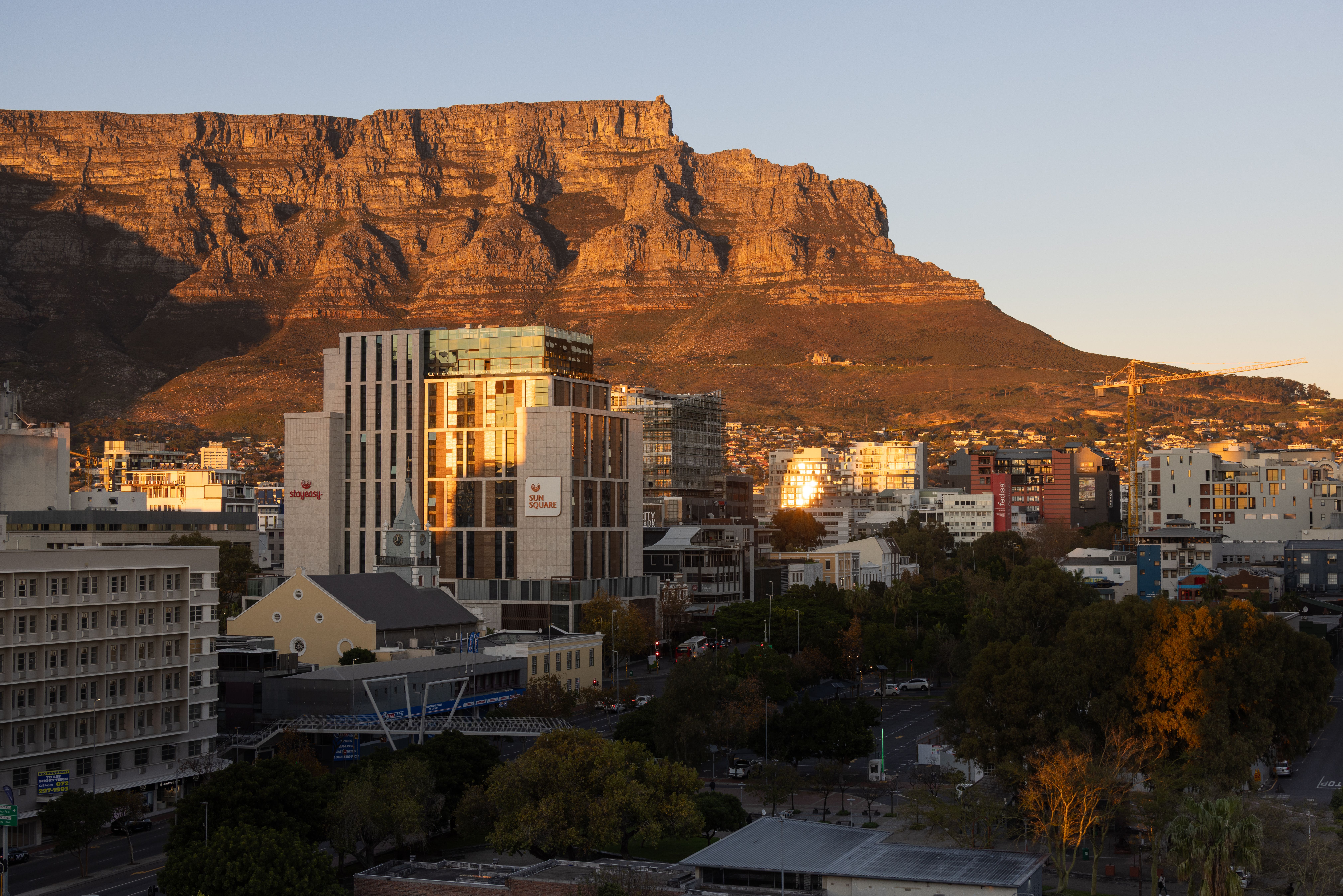 View of Cape Town's skyline with Table Mountain in the background during sunset.