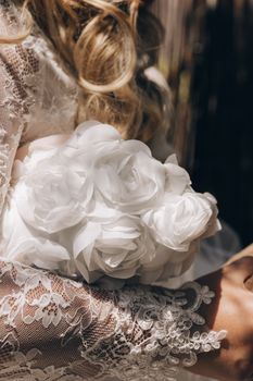 Close-up of a bridal bouquet featuring white roses and intricate lace detail.