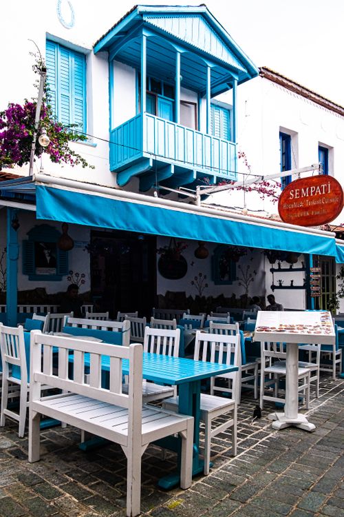 Free Charming outdoor café with blue and white decor offers a cozy Mediterranean dining experience. Stock Photo