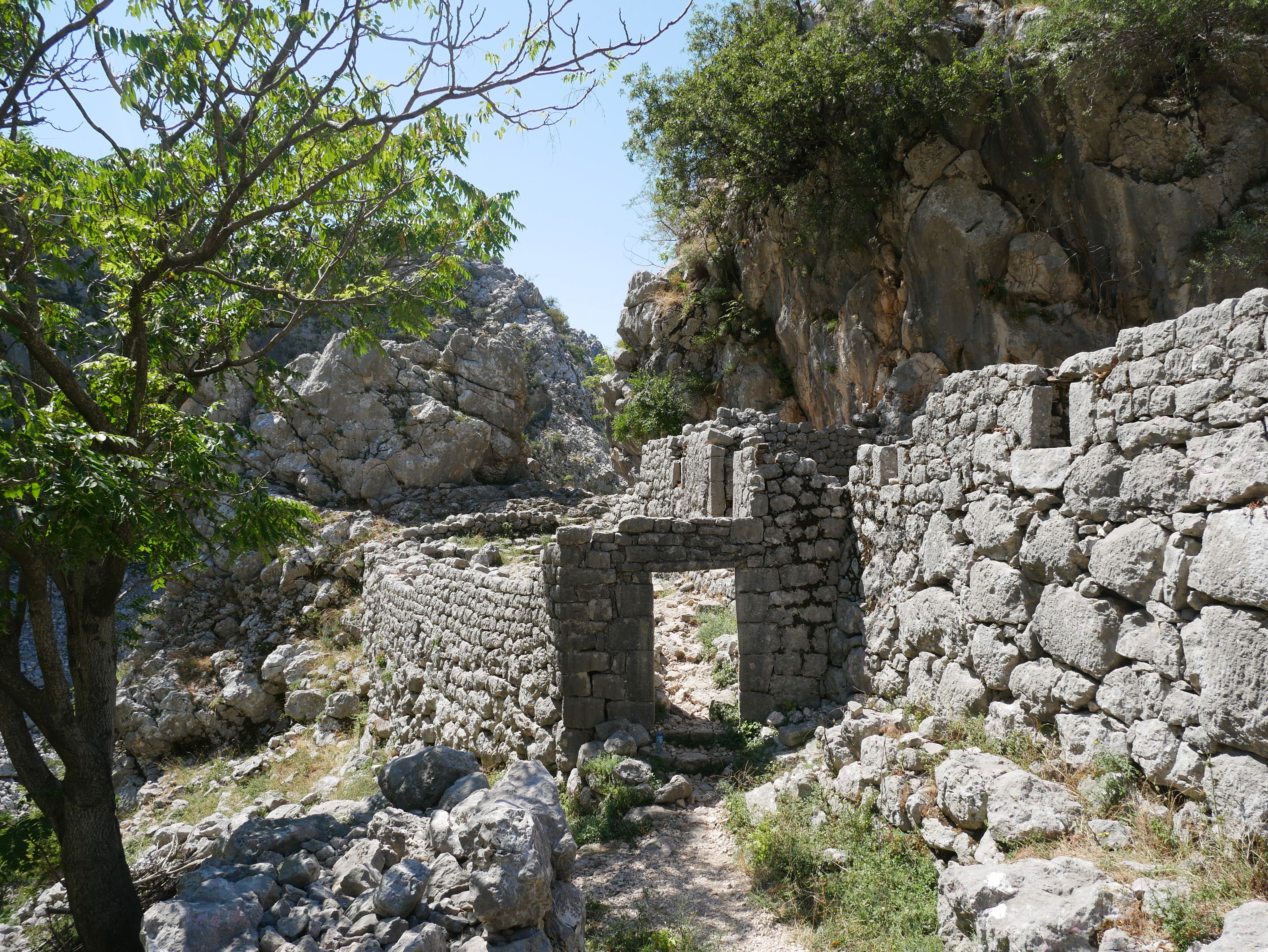 Explore the ancient stone wall ruins set in a rocky landscape in Montenegro, surrounded by natural beauty.