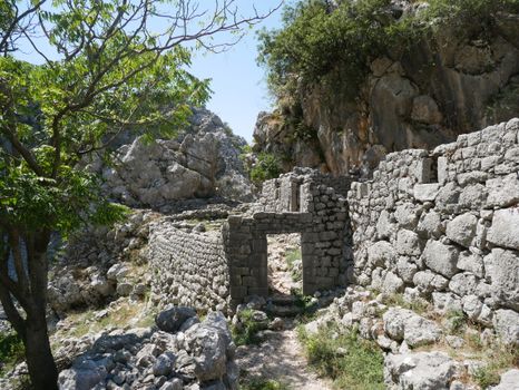 Explore the ancient stone wall ruins set in a rocky landscape in Montenegro, surrounded by natural beauty.