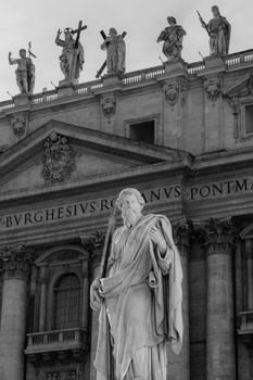 Black and white photo capturing the detailed sculptures atop St. Peter's Basilica in Rome, Italy.