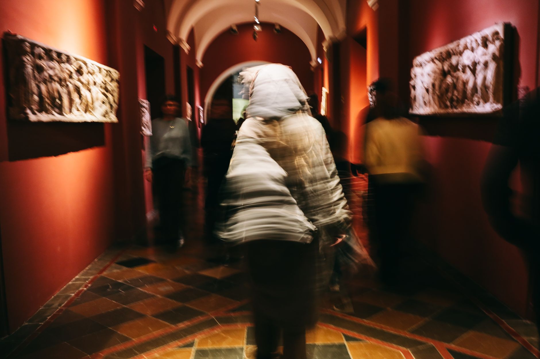 Imagen de archivo: Imágenes borrosas de personas en una galería de arte con iluminación dramática y esculturas históricas.