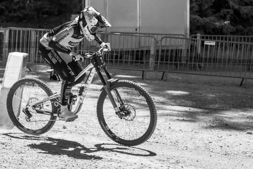 Free Dynamic black and white image of a cyclist racing down a trail in Switzerland. Stock Photo