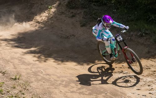 Free A biker in vibrant gear navigates a dirt track during a sunny day in Vaz, Switzerland. Stock Photo