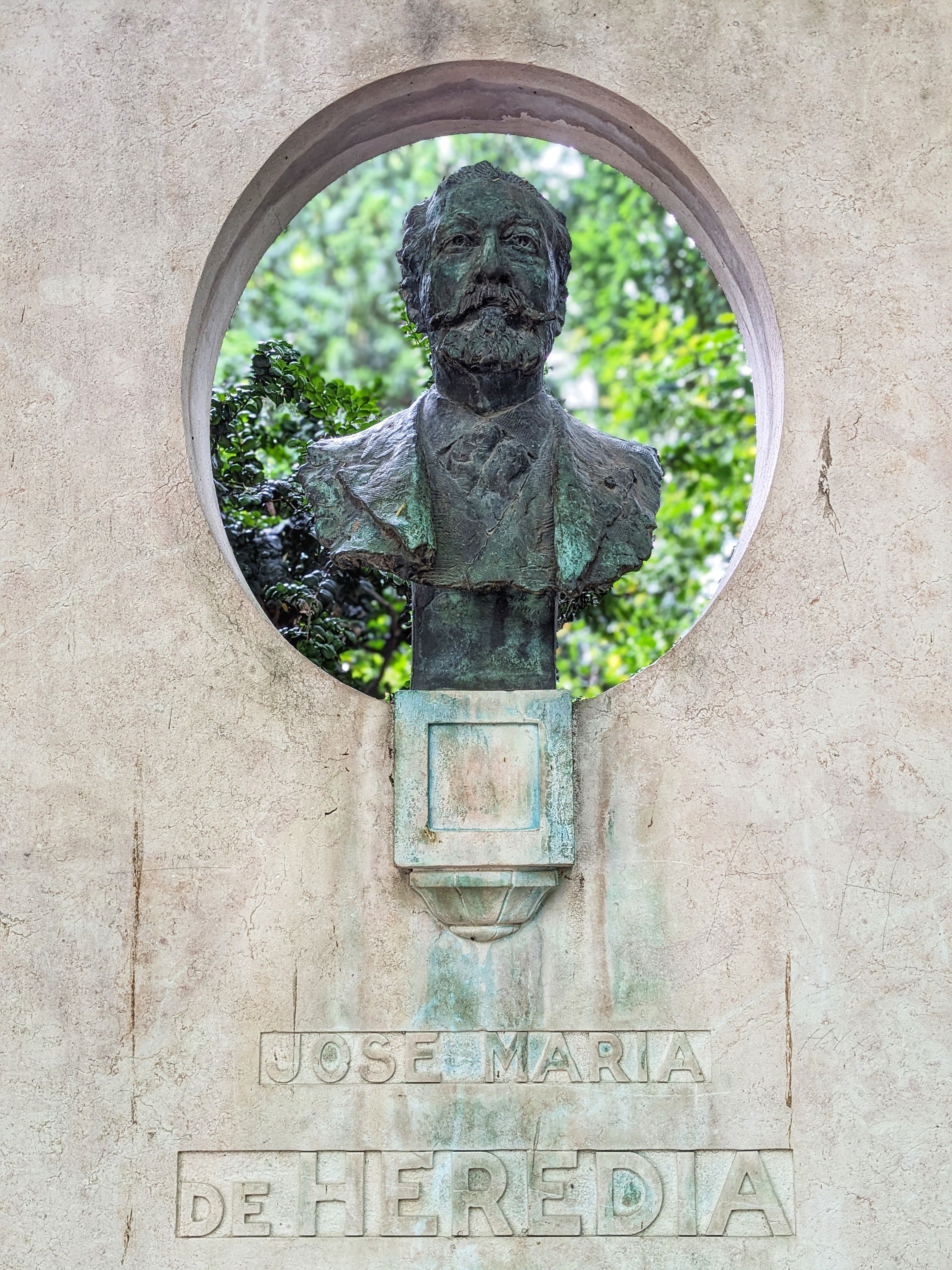 Bronze bust of José Maria de Heredia set in a stone niche in Paris.