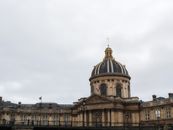 A classic view of the Institute of France, showcasing Parisian architectural elegance under a cloudy sky.
