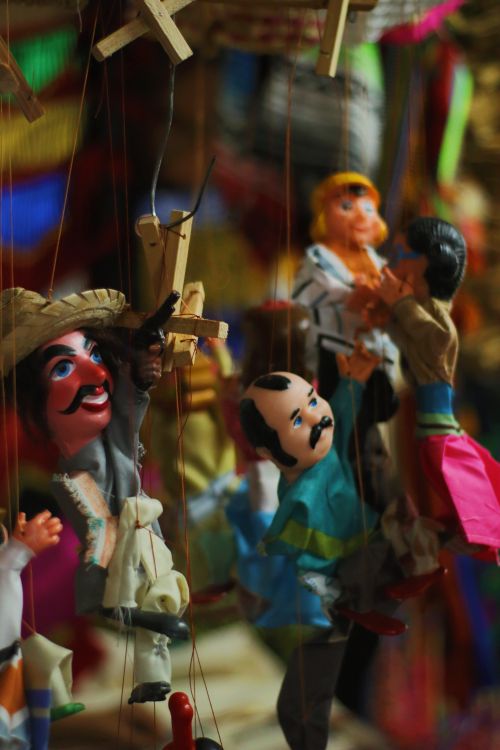 Free Vibrant handcrafted puppets with traditional attire on display. Stock Photo