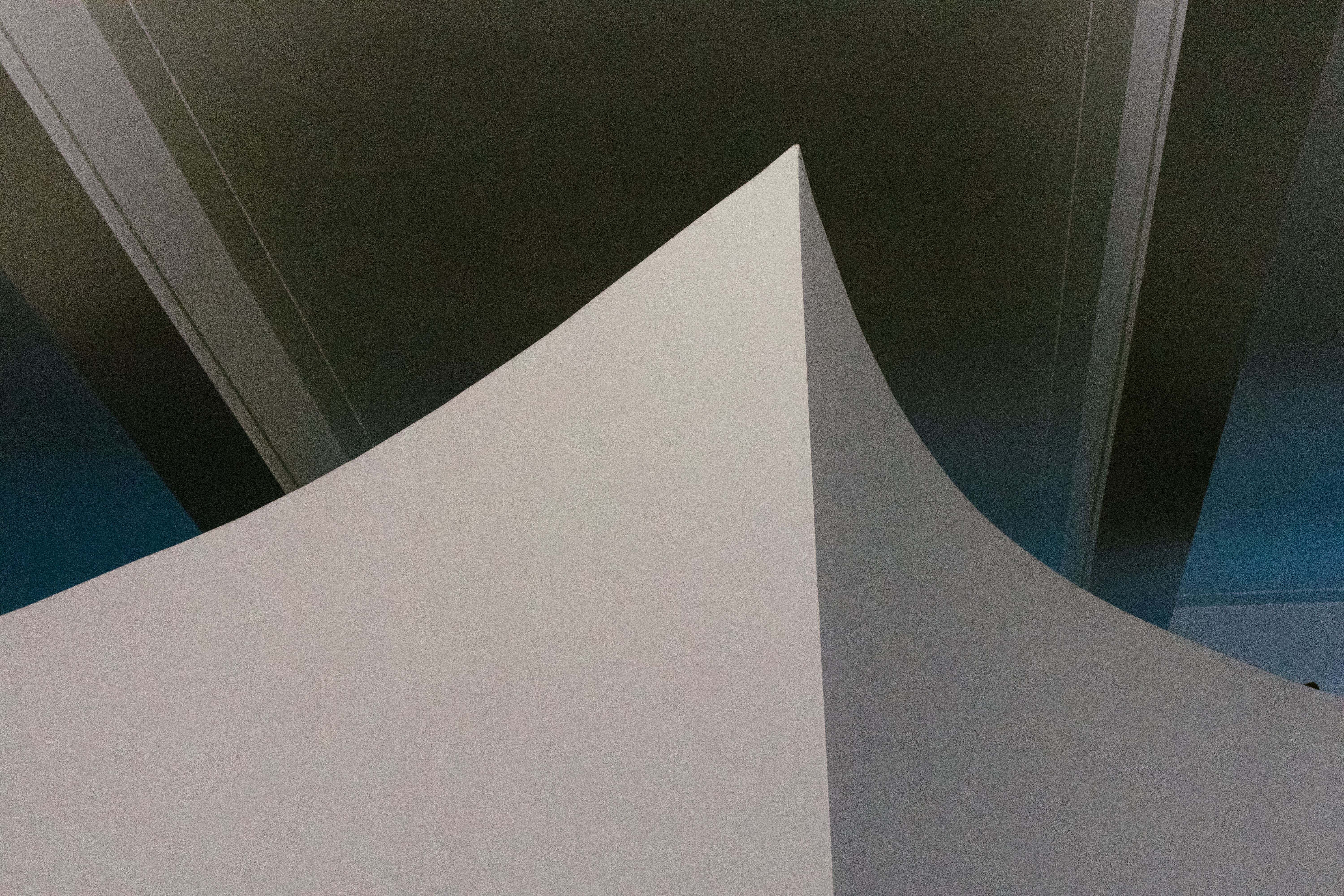 Minimalist architectural design featuring sharp geometric lines and curves indoors.
