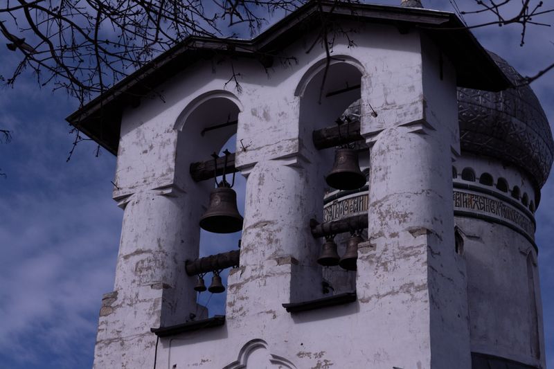 A historic church bell tower showcasing rustic architecture against a clear blue sky.