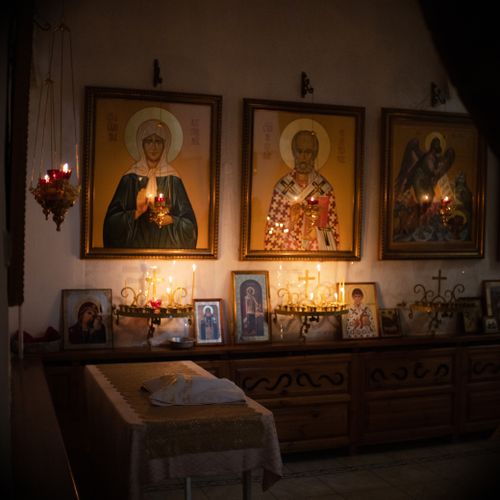 Free Candlelit religious icons create a serene atmosphere in an indoor worship space. Stock Photo