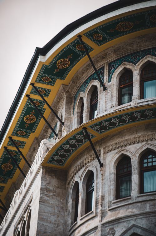 Free Close-up of a decorative building facade with arches and colorful geometric designs. Stock Photo