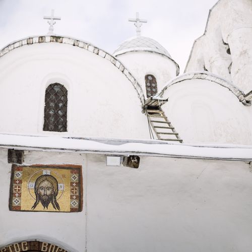 Free A white Orthodox church with intricate mosaic of Jesus, showcasing religious architecture. Stock Photo
