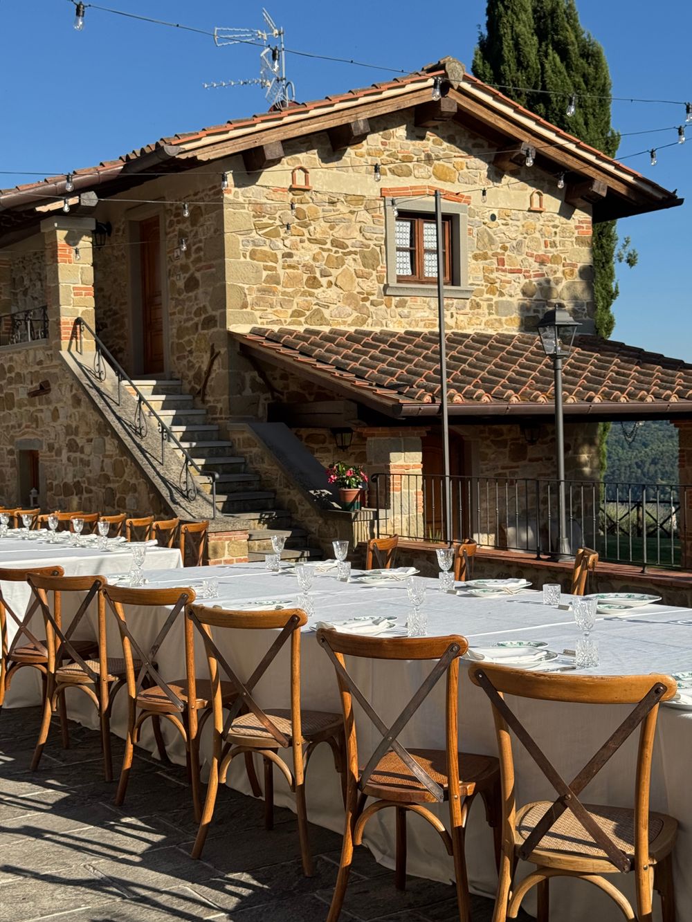 Masă pusă în aer liber la o vilă din Toscana, cu vedere spre dealuri