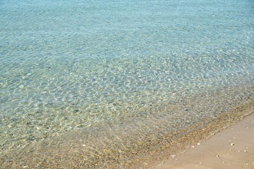 Free Serene clear water lapping at the sandy beach in Provence, capturing tranquility. Stock Photo