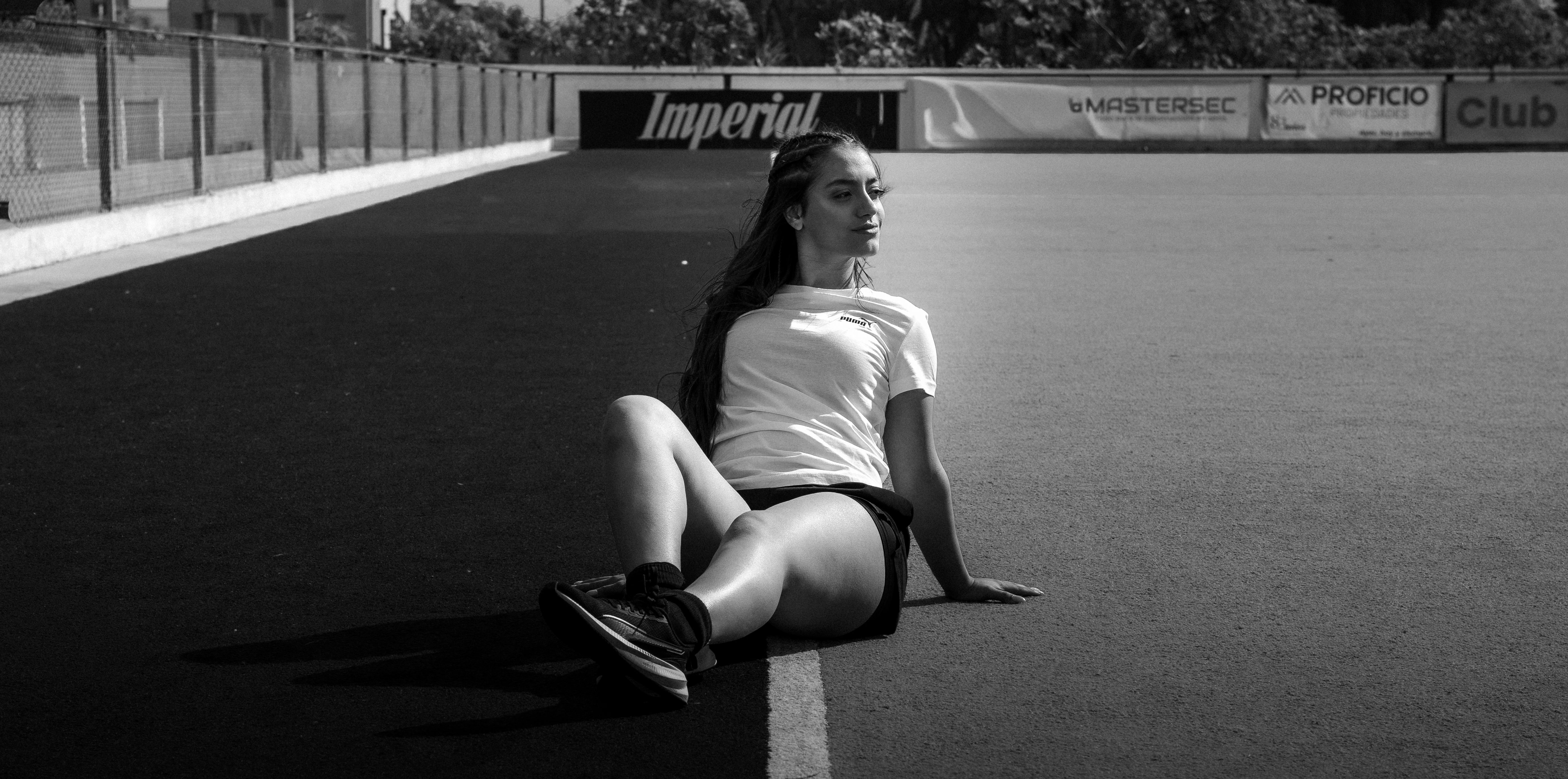Young girl watching a female athlete with wide eyes, holding a sign