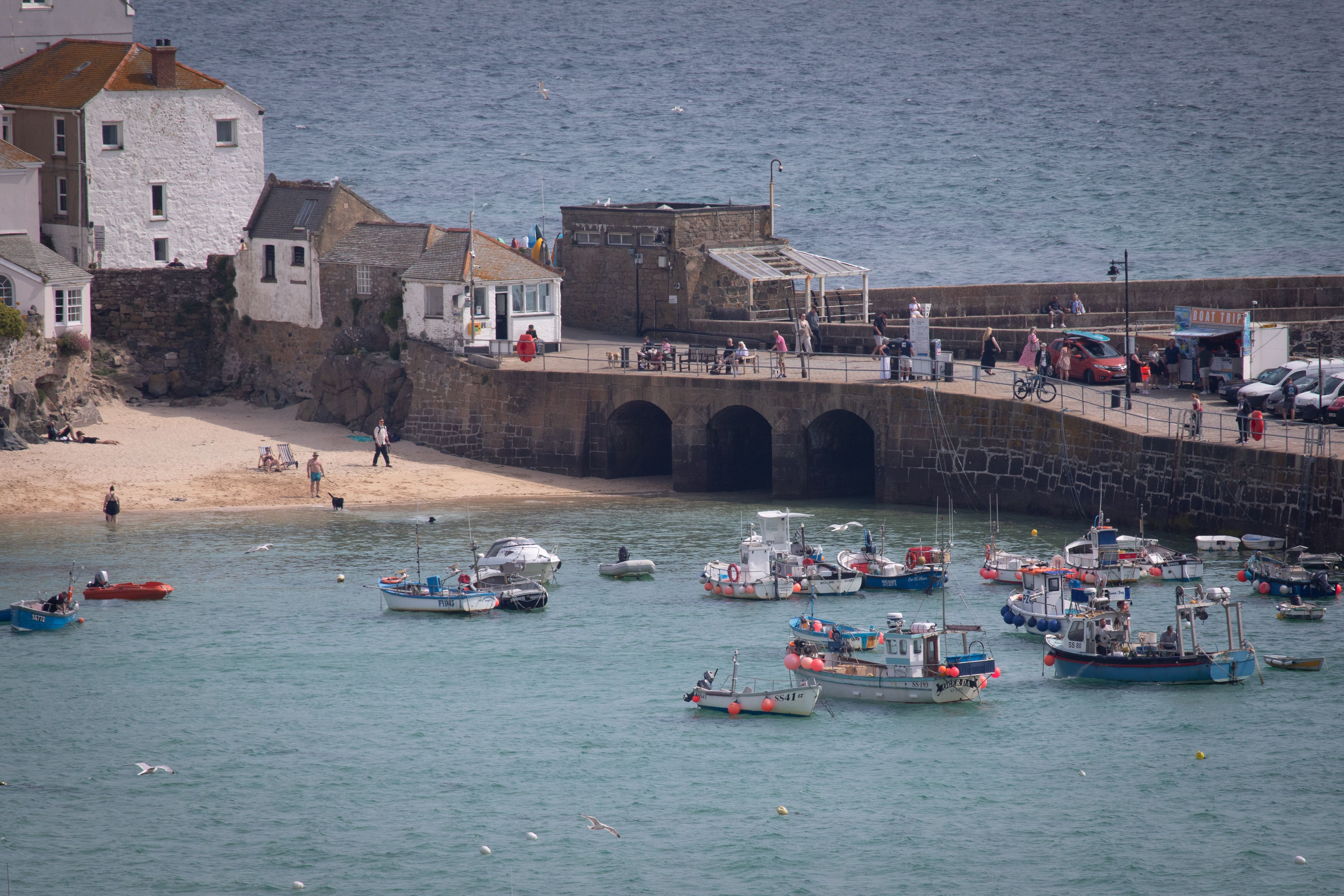 A picturesque view of St Ives harbor with boats and seaside buildings on a sunny day.
