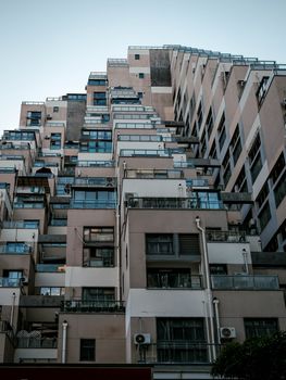 A striking view of a modern, geometric apartment building facade during the day.