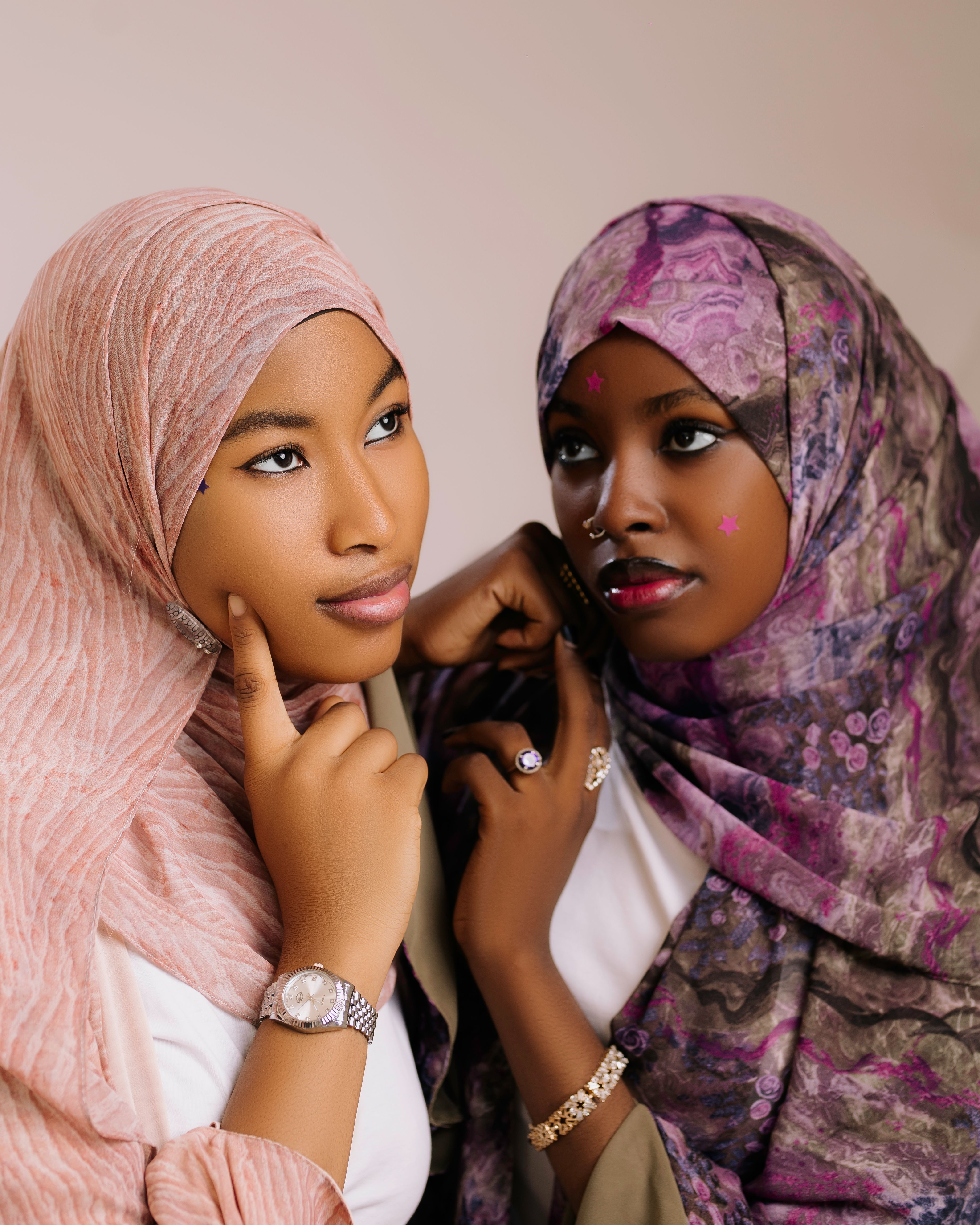 Elegant portrait of two women in colorful hijabs posing together.