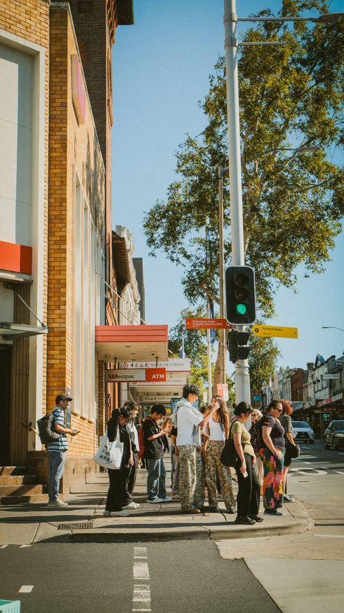 Free A lively urban street scene with pedestrians waiting at a city intersection. Stock Photo