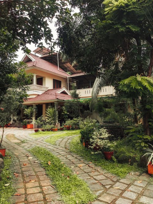 Free Beautiful villa with a paved path and vibrant garden, perfect for serene retreats. Stock Photo