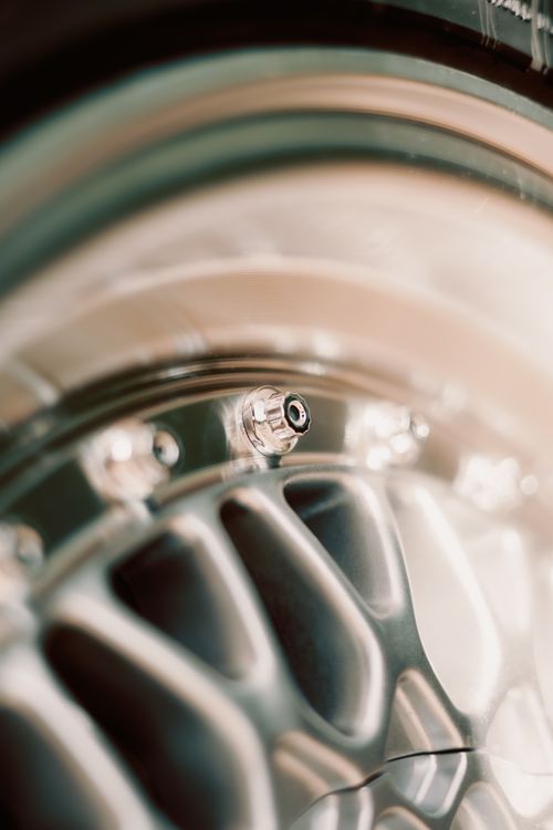Free Artistic close-up of a shiny car wheel rim, highlighting metallic texture and design. Stock Photo
