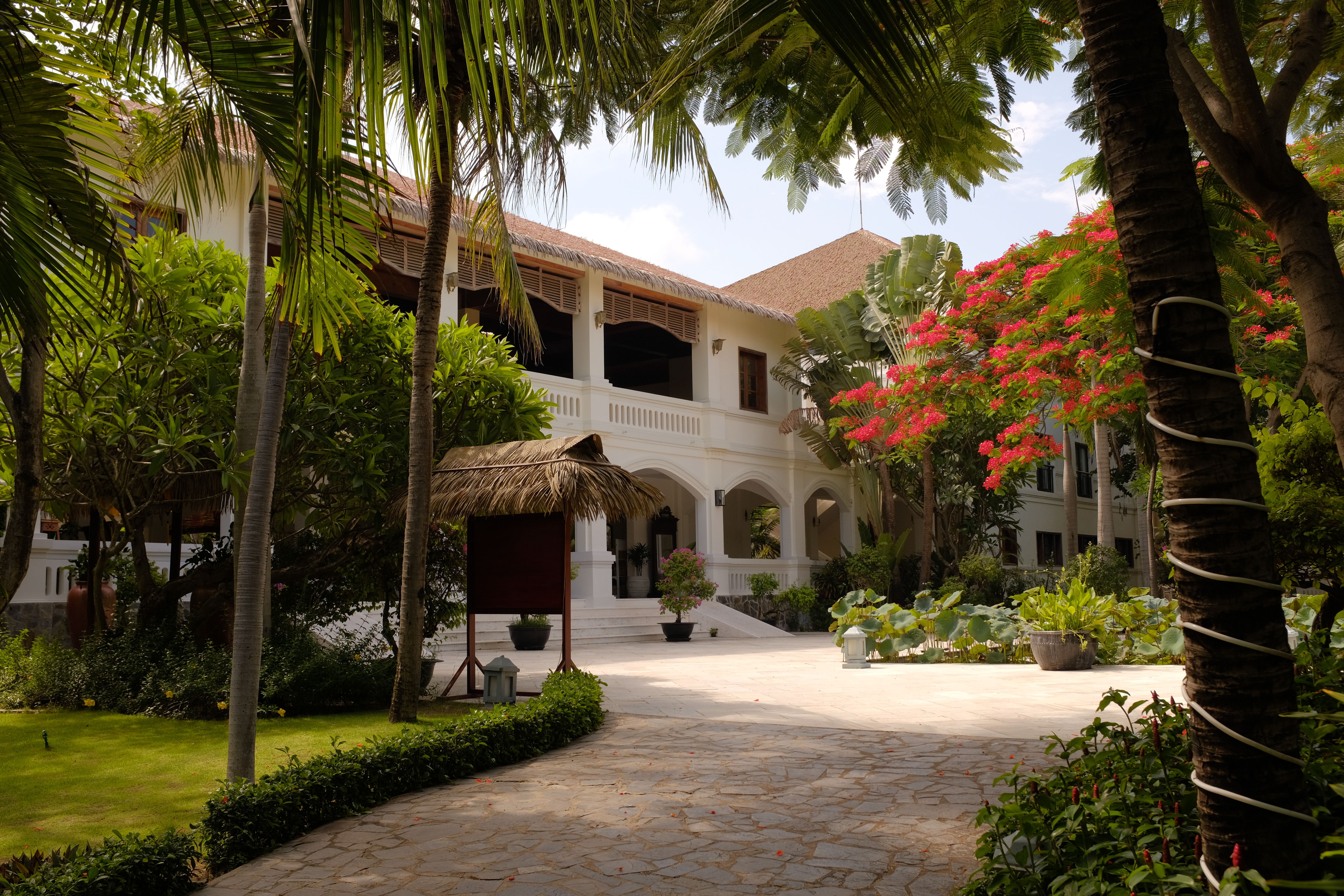 Tranquil resort in Mũi Né, Vietnam showcasing beautiful French colonial architecture amid lush gardens.