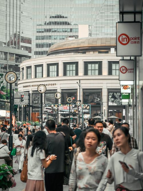 Free Urban street scene with diverse crowd near a contemporary building in a bustling city. Stock Photo